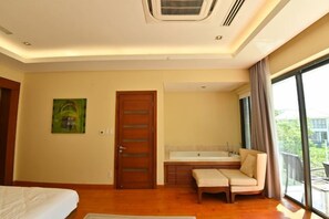 Habitación de hotel con un ventanal grande, una cama, un sofá y un baño.