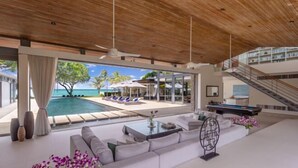 A modern living room with a pool, outdoor seating, and a view of the ocean. - Sava Villa 3 Villa Cielo (Takua Thung)