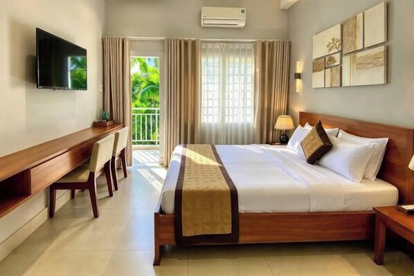 A hotel room with a bed, a desk, a television, and a balcony with curtains. - NGOC CHAU HOTEL (Ho Chi Minh City)