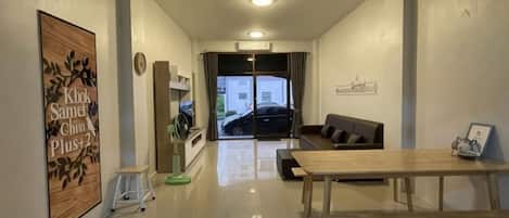 Un interior moderno con una zona de comedor, un sofá y vistas al exterior.