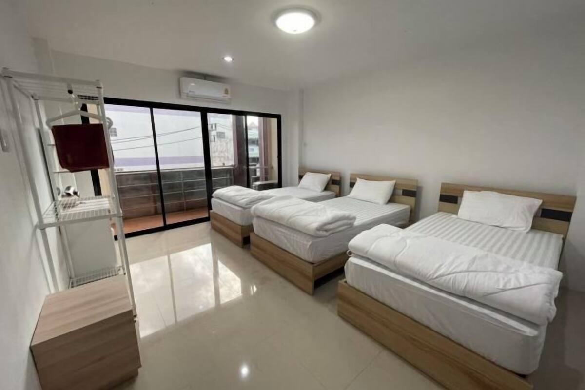 A hotel room with two beds, a balcony, and a white color scheme.
