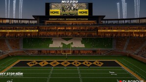 A stadium with multiple levels of seating, a large field, and a scoreboard displaying a football game. - Upscale 2-bedroom luxury loft in vibrant downtown Columbia, MO, in The District (Columbia)