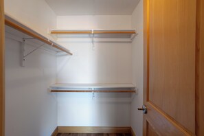 A small, empty walk-in closet with wooden shelves and a door. - Upscale 2-bedroom luxury loft in vibrant downtown Columbia, MO, in The District (Columbia)
