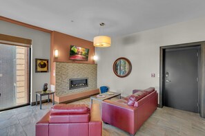 A modern living room with a fireplace, a sofa, a coffee table, and a television. - Upscale 2-bedroom luxury loft in vibrant downtown Columbia, MO, in The District (Columbia)