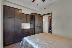 A bedroom with a bed, a wardrobe, and a door leading to a bathroom. - Upscale 2-bedroom luxury loft in vibrant downtown Columbia, MO, in The District (Columbia)