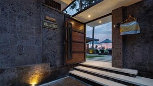 A villa entrance with a stone facade, a wooden door, and a sign reading 'Villa Eden.' - Villa Eden by BaliSuperHost (Bali)