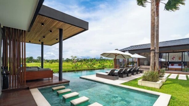 A modern outdoor pool area with lounge chairs and a wooden deck. - Villa Eden by BaliSuperHost (Bali)