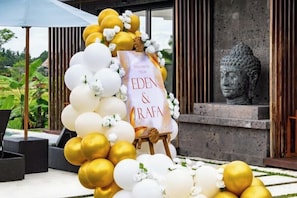 A decorative setup with a banner for Eden & RaFA, surrounded by white and gold balloons, with a Buddha statue in the background. - Villa Eden by BaliSuperHost (Bali)