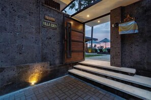 A villa entrance with a sign, steps leading up to the door, and a view of the outside. - Villa Eden by BaliSuperHost (Bali)