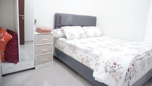 Een slaapkamer met een bed, een kledingkast en een spiegel.