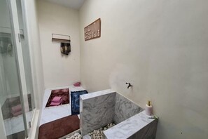 Casa de banho pequena e funcional, com zona de duche, lavatório e sanita.