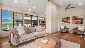 A modern living room with a sofa, chairs, a coffee table, and artwork on the walls.