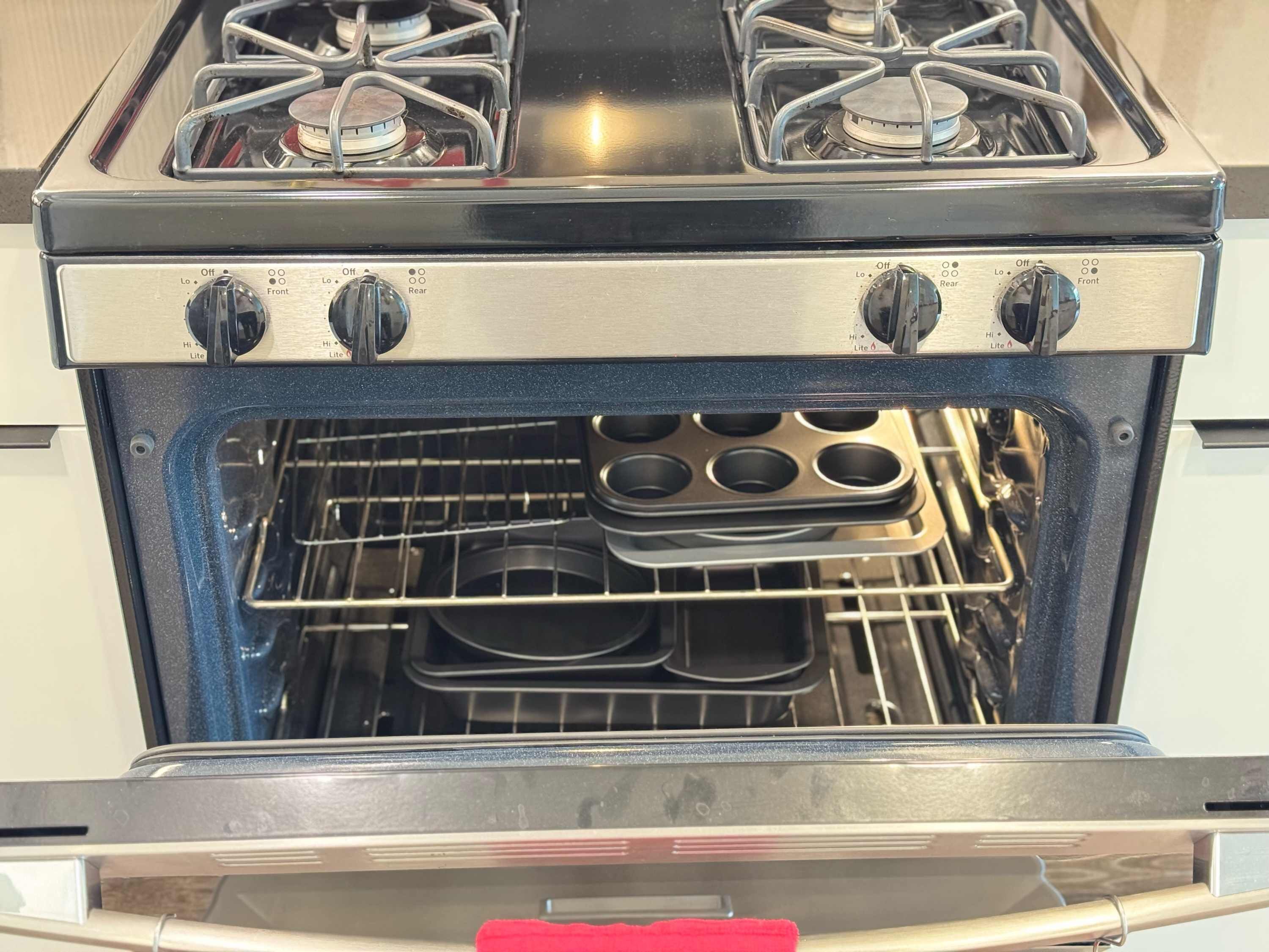 An open oven with muffin pans inside.