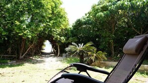 Un jardín con un sendero que lleva a una terraza de madera.