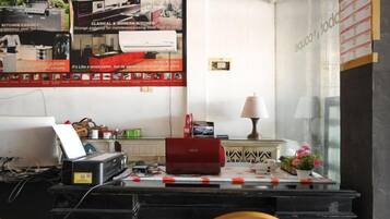 A kitchen area with a countertop, a red appliance, and a wall-mounted air conditioner.