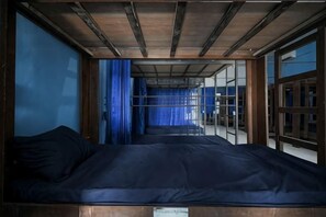 Una habitación con cama, ventana con cortinas y vistas al exterior.