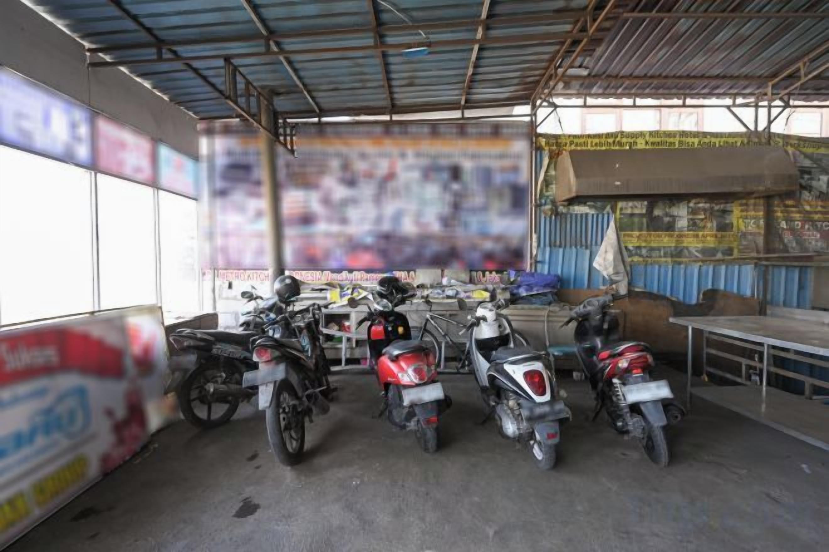 Uma área de estacionamento coberta com várias motocicletas estacionadas.