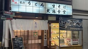 Un restaurante con un letrero que muestra su nombre y los platos del menú.