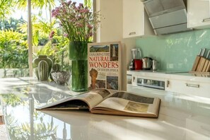Una cucina con un libro intitolato 'EFLONGTH THE NATURAL WONDER' e un vaso verde con fiori sul bancone.