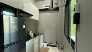 Une cuisine compacte équipée d’un réfrigérateur, d’un four à micro-ondes et d’un évier.