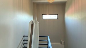 Un escalier muni d’une rampe et d’un luminaire placé au-dessus.