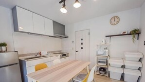 A modern kitchen with a dining table, chairs, and a microwave. - GLOCE Guest House Nagisa 5 mins from the station (Zushi)