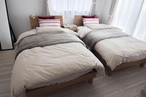 A double bed with a wooden frame, two bedside tables, and a window with curtains. - GLOCE Guest House Nagisa 5 mins from the station (Zushi)