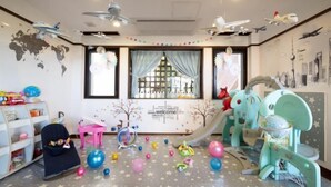 A children's playroom with a slide, play area, and educational toys. - Amano Terrace (Onna)