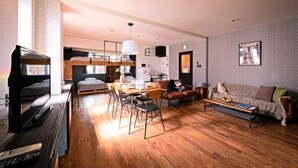 Et moderne hotelværelse med køjeseng, spiseplads, sofa og sofabord.