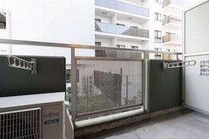 A modern building with a gated entrance, a metal fence, and a Fujitsu air conditioning unit. - Access Bunkyo Otsuka (Tokyo)
