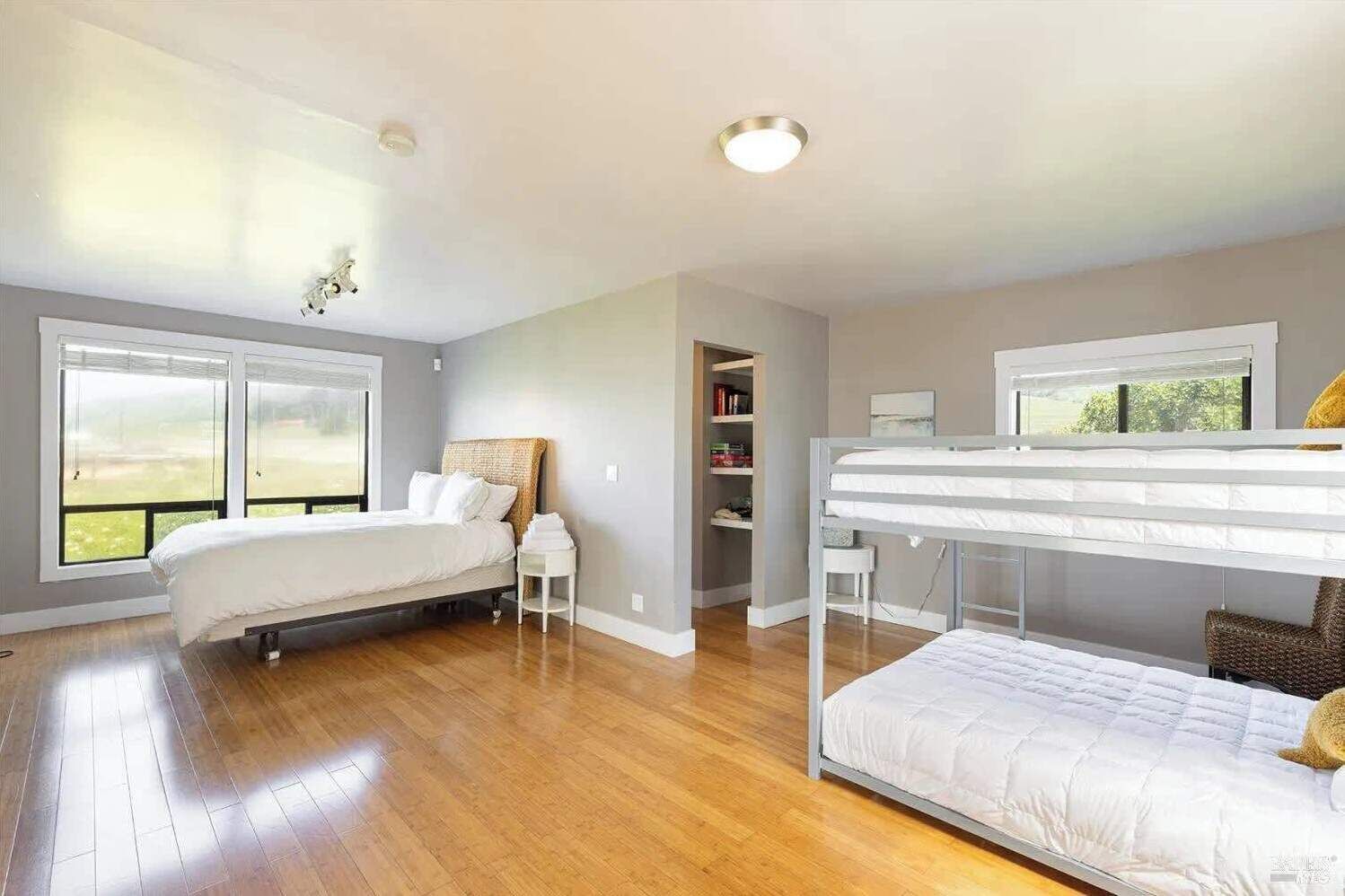 Ein geräumiges Schlafzimmer mit einem großen Bett, einem Etagenbett und einem begehbaren Kleiderschrank.