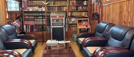 A library with leather sofas, bookshelves, and a vintage radio.