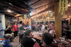 Un restaurante con decoración de madera, mesas y sillas, y personas cenando.