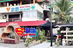 Un edificio con un letrero que dice 'Super Diving TINAS REEF DIVERS' y un logotipo de Superman.