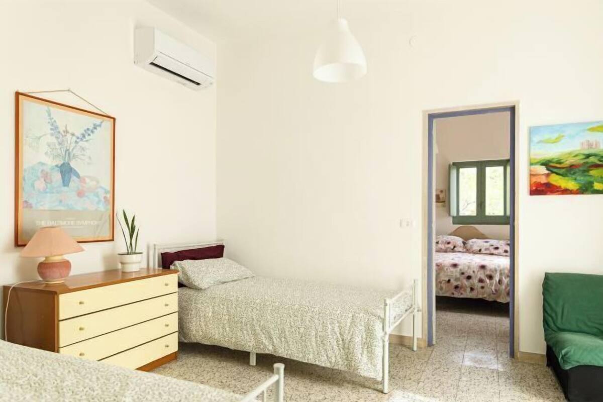 Een slaapkamer met een bed, een kaptafel en een schilderij aan de muur.