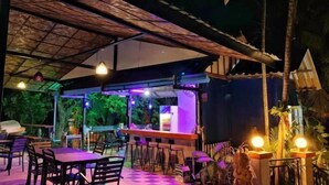An outdoor dining area with tables and chairs, a bar, and a covered seating area. - patong beautiful pool villa (Phuket)