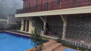 A two-story building with a swimming pool and a covered patio area. - Villa Zoya 1 (Megamendung)