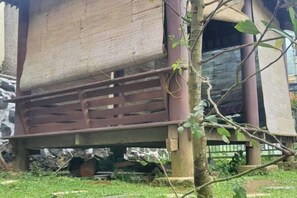 A structure with a wooden platform and a metal railing, surrounded by greenery. - Villa Zoya 1 (Megamendung)