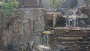 A rock formation with a small waterfall. - Villa Zoya 1 (Megamendung)