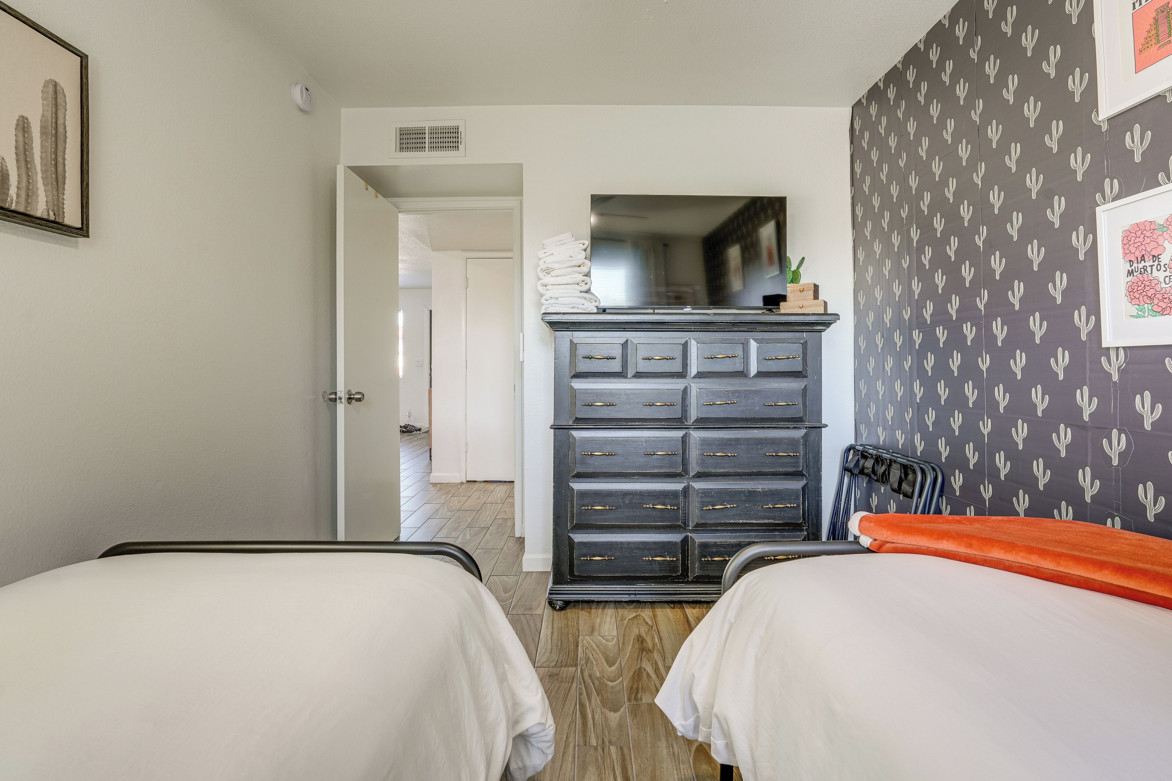 A hotel room with two beds, a dresser, and a mirror.