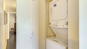 A laundry room with a white door, a washing machine, and a dryer. - Quiet & Convenient! Condo w/ Balcony Near ASU (Tempe)