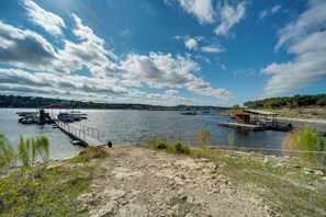 Une vue sur le lac, avec des quais, un pavillon couvert et une structure en bois sur la rive.