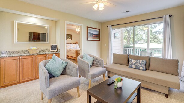 A living room with a sofa, two armchairs, a coffee table, a ceiling fan, and a large window with curtains. - Steps to Pool + Golf! Family Myrtle Beach Retreat (Myrtle Beach)