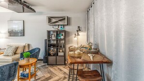 A modern living room with a sofa, chairs, a coffee table, a fireplace, a TV, and a bookshelf. - Steps to Shore + Pier: Condo in North Myrtle Beach (North Myrtle Beach)
