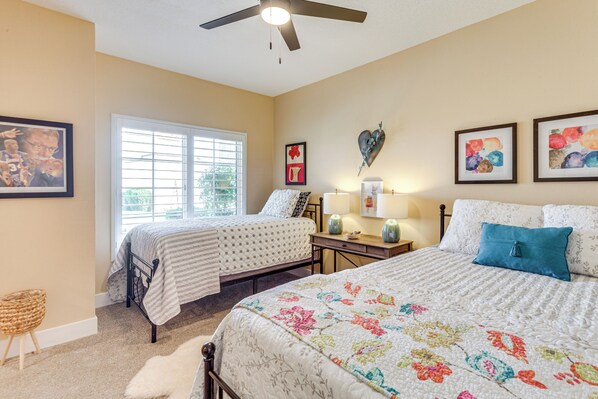 A bedroom with two beds, a ceiling fan, and a window with blinds. - Golf Course View & Pool Access: Palm Desert Condo (Palm Desert)