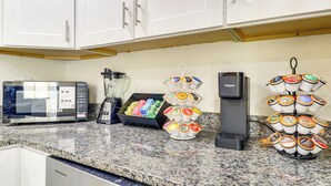 Eine Küche mit Mikrowelle, Kaffeemaschine und Kaffeeautomaten.