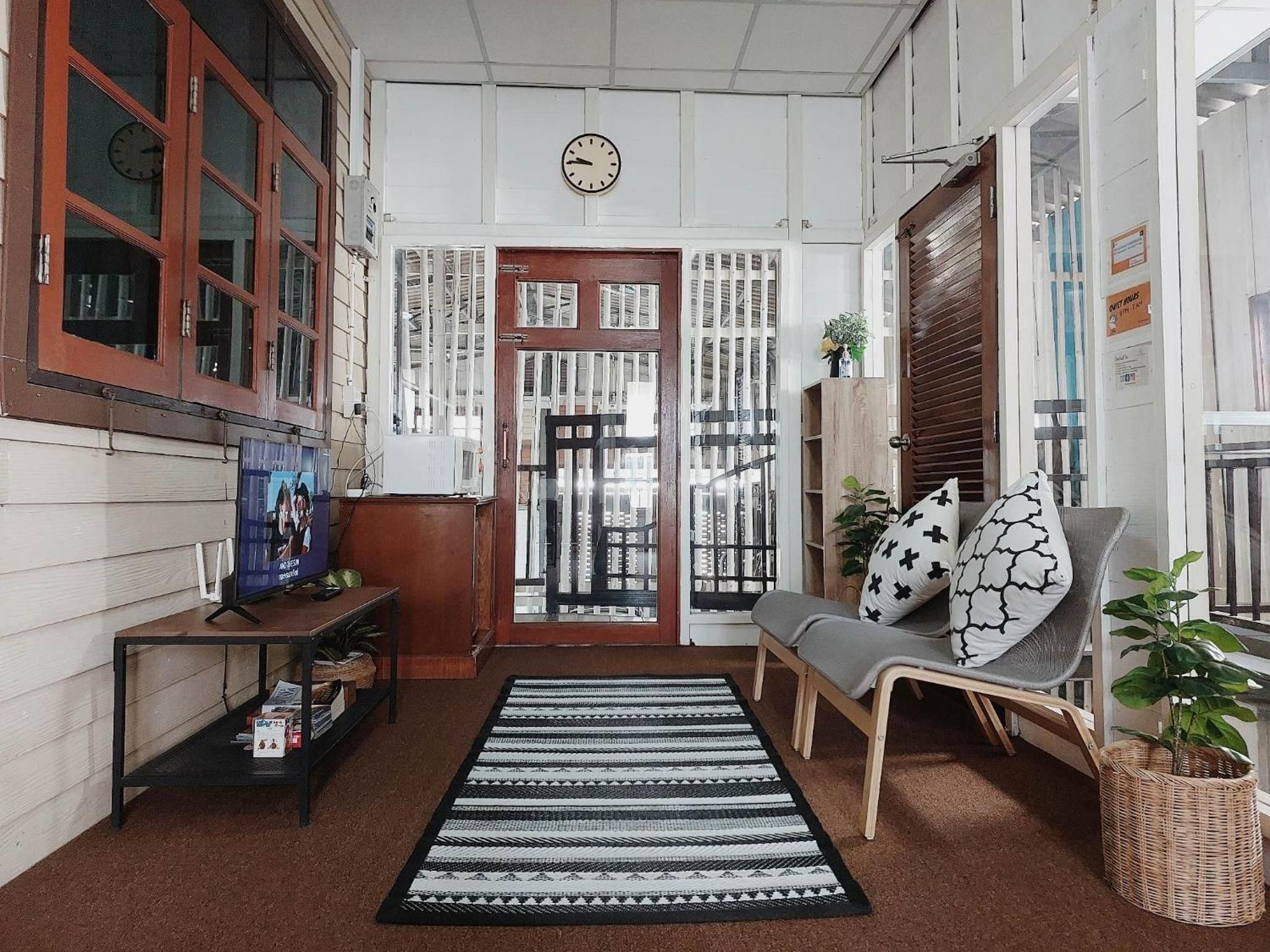 Un intérieur chaleureux avec un canapé, un téléviseur et un tapis à motifs.