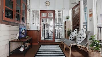 Un interior acogedor con un sofá, un televisor y una alfombra estampada.