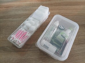 Two clear plastic containers with various items, including cotton swabs and personal care products, on a wooden surface. - The Warehouse - Ayutthaya (Ayutthaya)