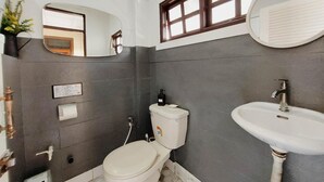 A bathroom with a toilet, sink, mirror, and a window. - The Warehouse - Ayutthaya (Ayutthaya)